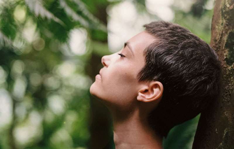 woman breathing deeply in a forest