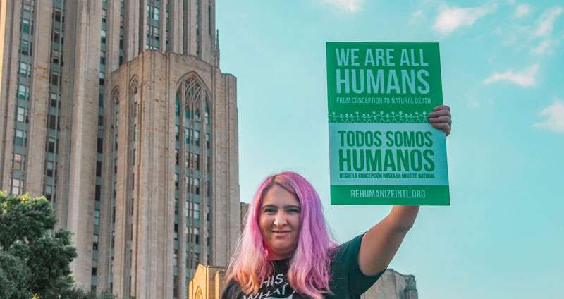 woman holding a sign for immigrants