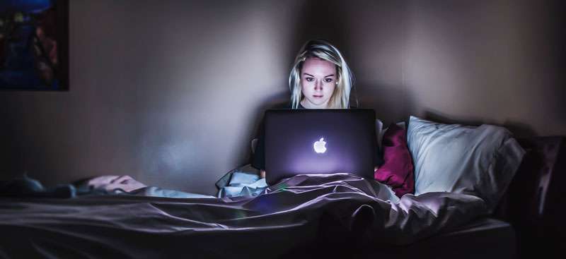 woman looking at pics on her laptop with envy