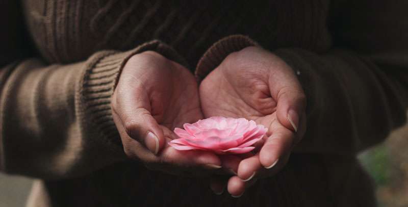 woman meditating and holding a flower