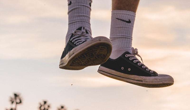 feet of a man jumping happily