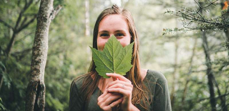 woman holding a leaf in front of her