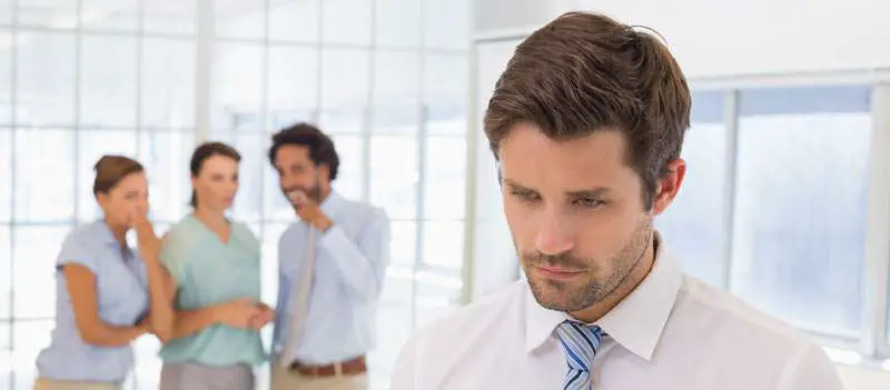 man being criticized by colleagues at work