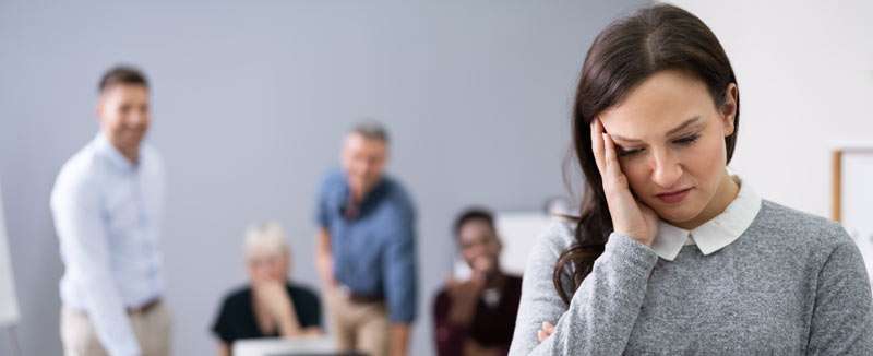 woman feeling hurt with colleagues criticizing