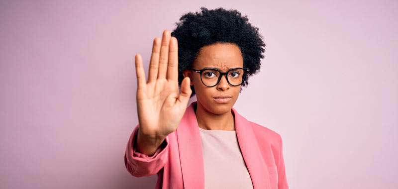 woman saying no with her hand and with a pink jacket