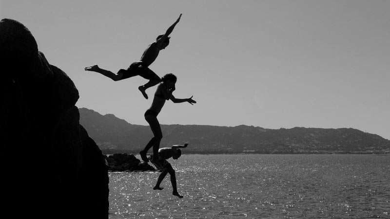 people jumping in the ocean.