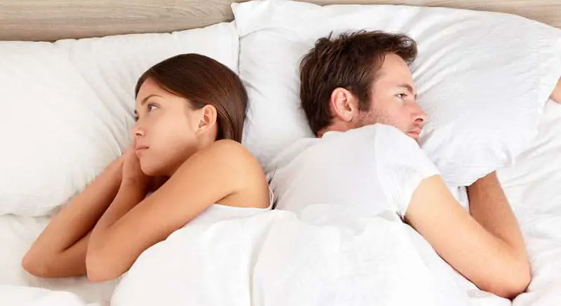 couple in bed feeling angry
