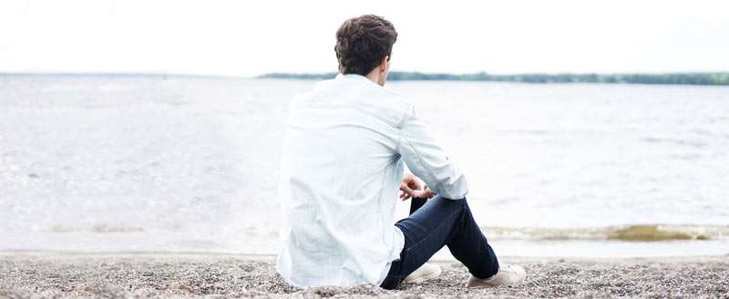 man feeling depressed looking at the ocean