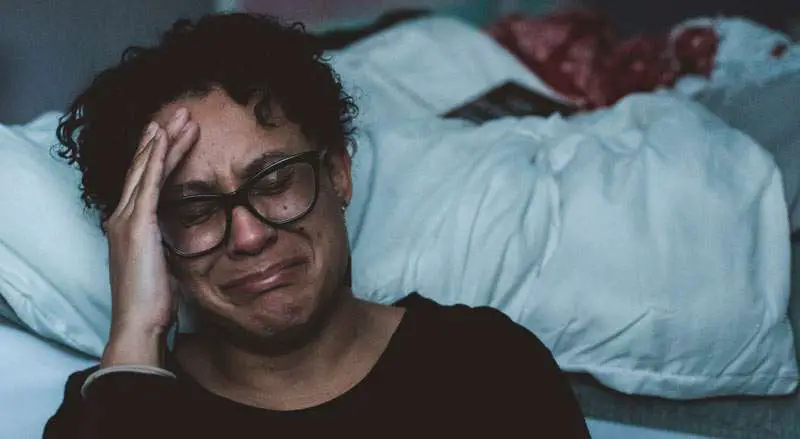 woman crying near her bed