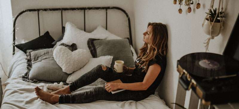 woman feeling sad on her bed