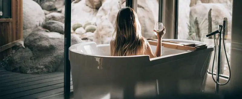 woman taking a bath with a glass of water