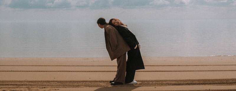 2 women posing on the beach as a couple