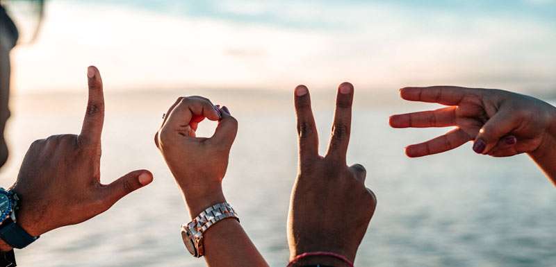 couple mimicking teh letters of love with their fingers