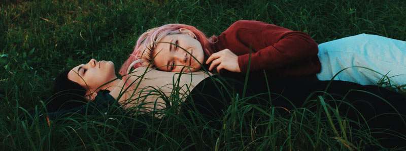 lesbian couple lying on the grass