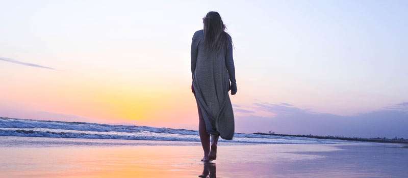 woman walking on the beach on her own