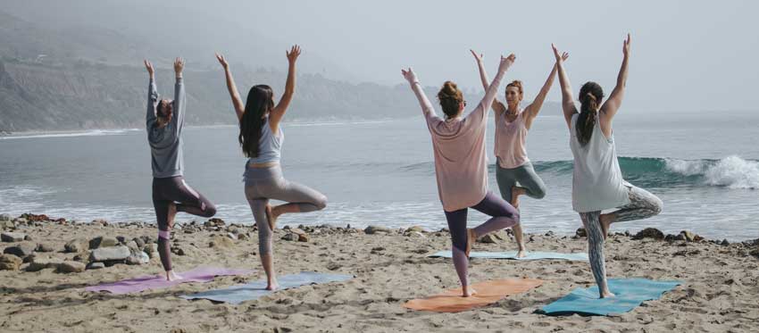 women doing yoga on the beach