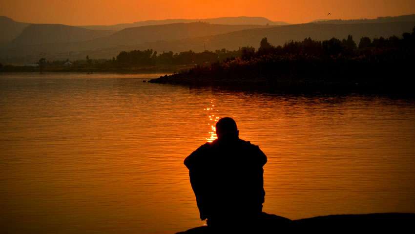 man alone in front of the river thinking