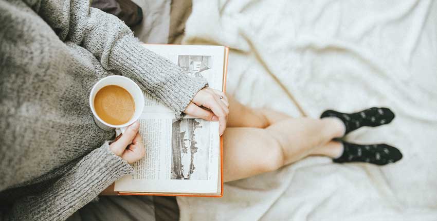 person reading and drinking coffee